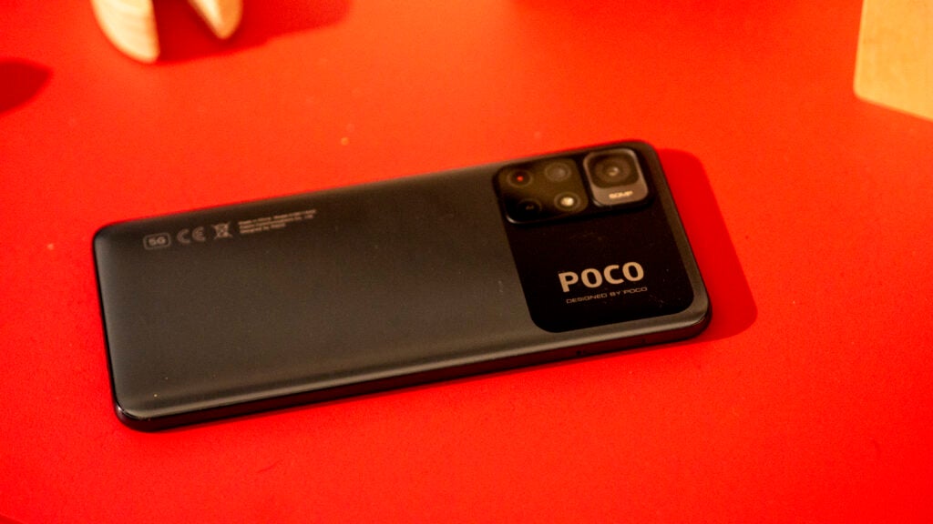 Rear panel of the Poco M4 Pro 5G, on a red surface