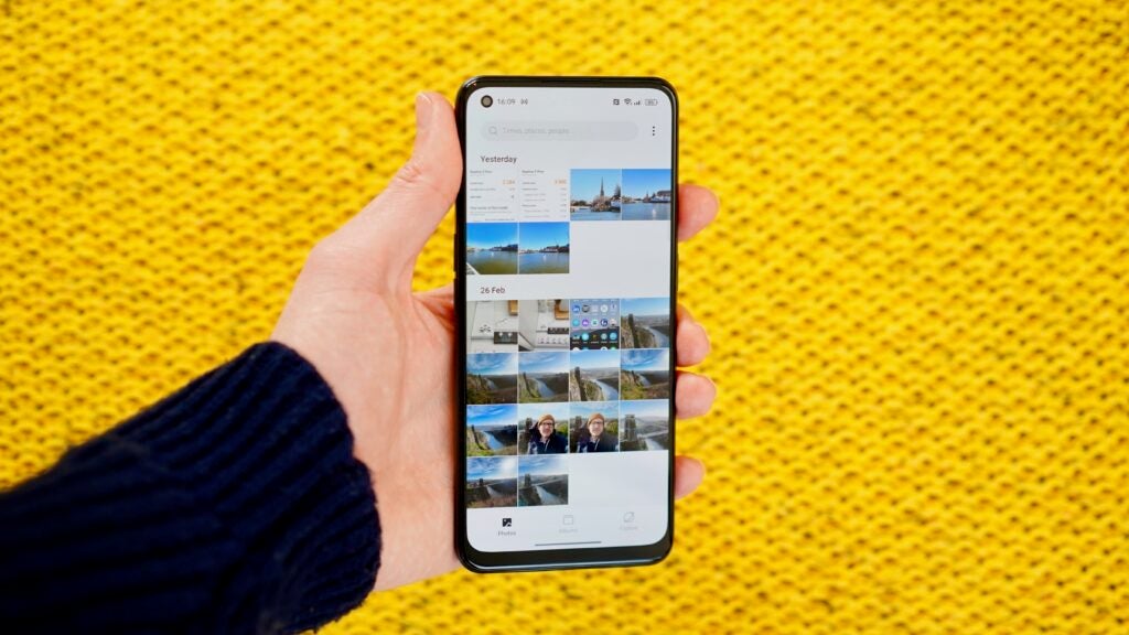 Realme 9 Pro Plus camera gallery open in front of a yellow background