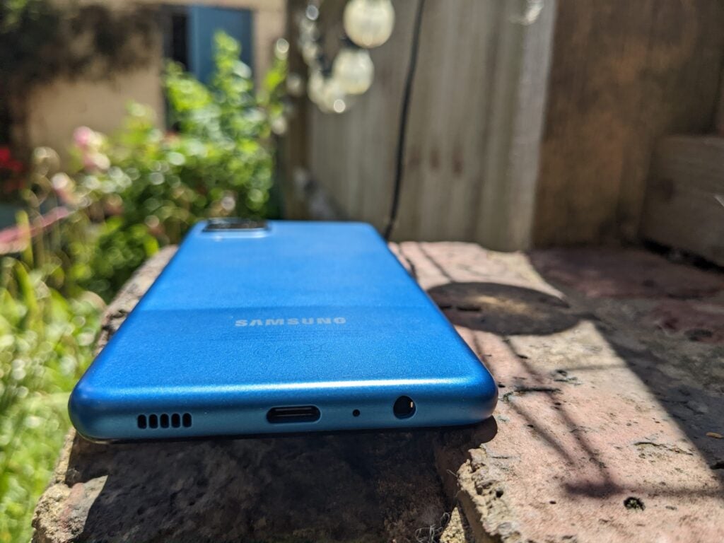Samsung Galaxy A12 en el suelo, mostrando el panel posterior desde abajo